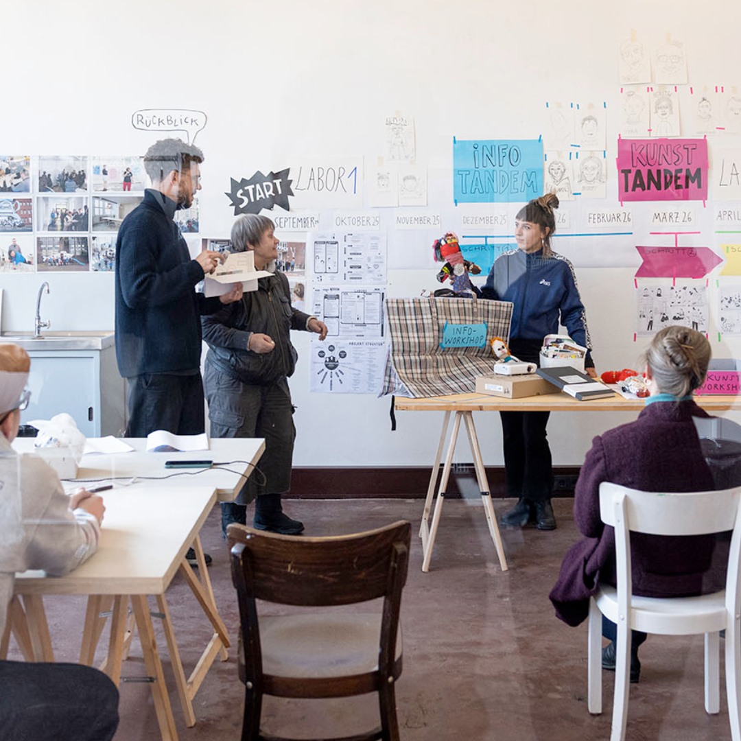 Menschen in einem Workshopraum bei einer Präsentation.