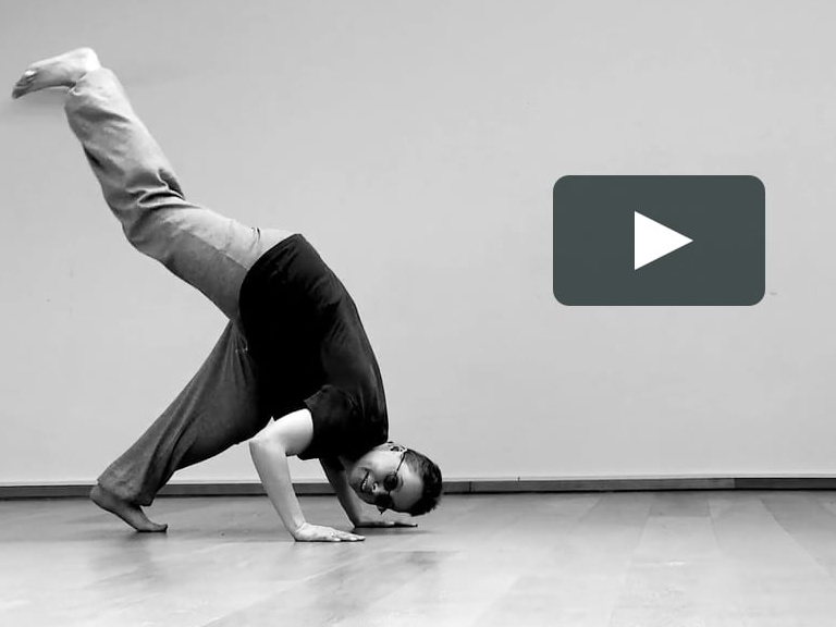 ein Tänzer macht einen halben Handstand, schwarz-weiß